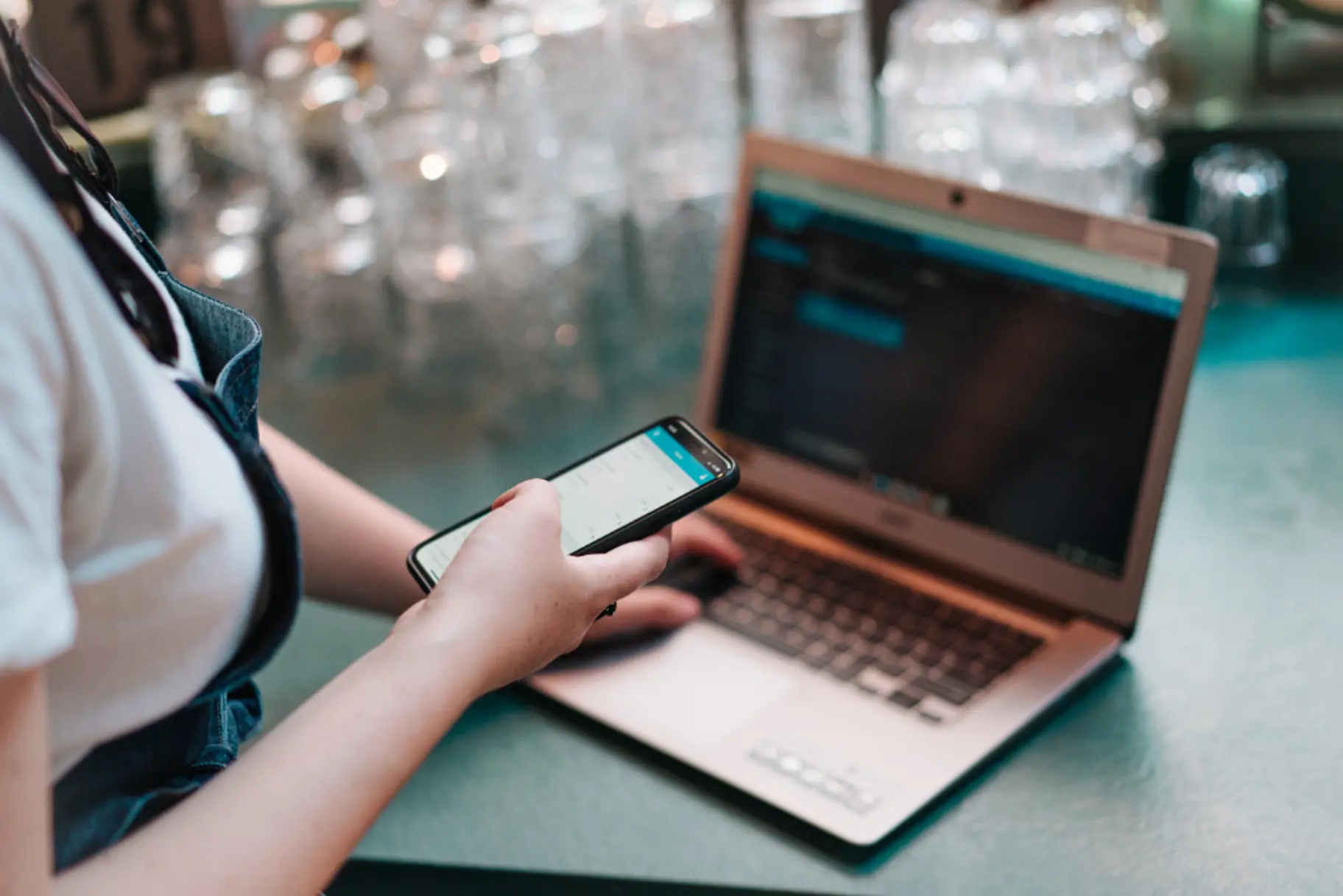 Horecamedewerker logt in op telefoon en laptop