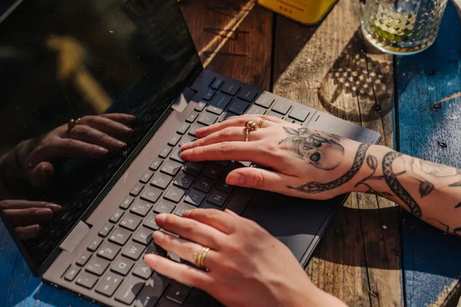 Personeel typt op laptop handen met tattoos