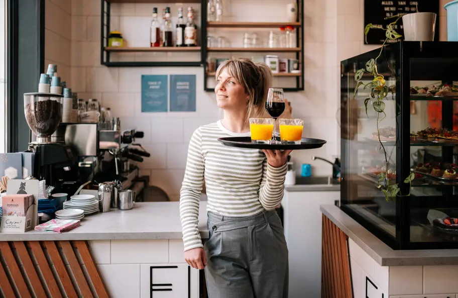Barmedewerkster met dienblad met koffie en jus